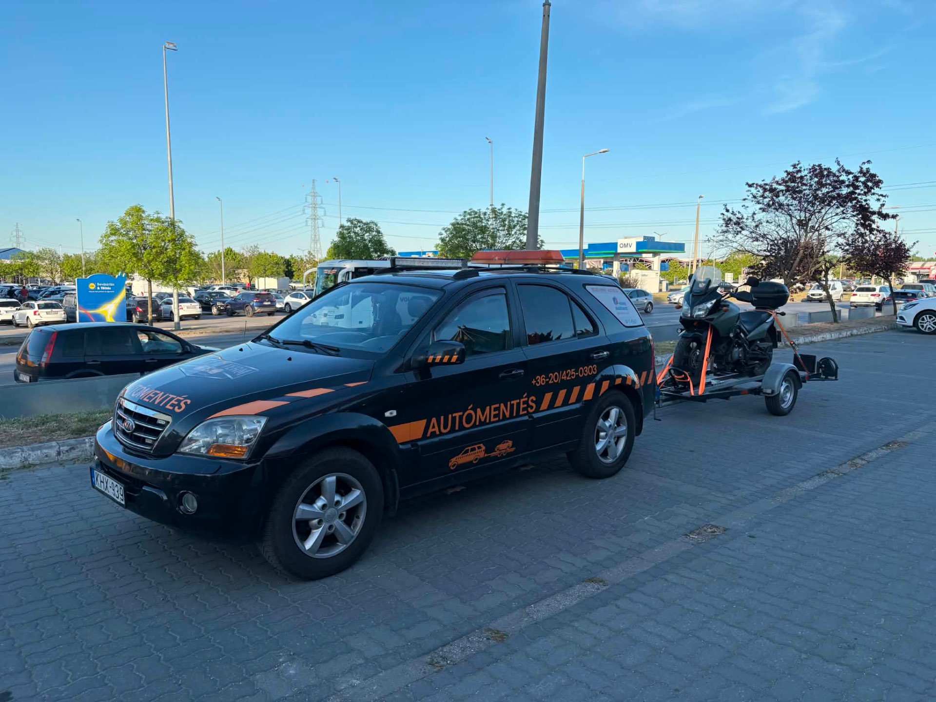 Piros Volkswagen Bogár szállítása platós trélerrel